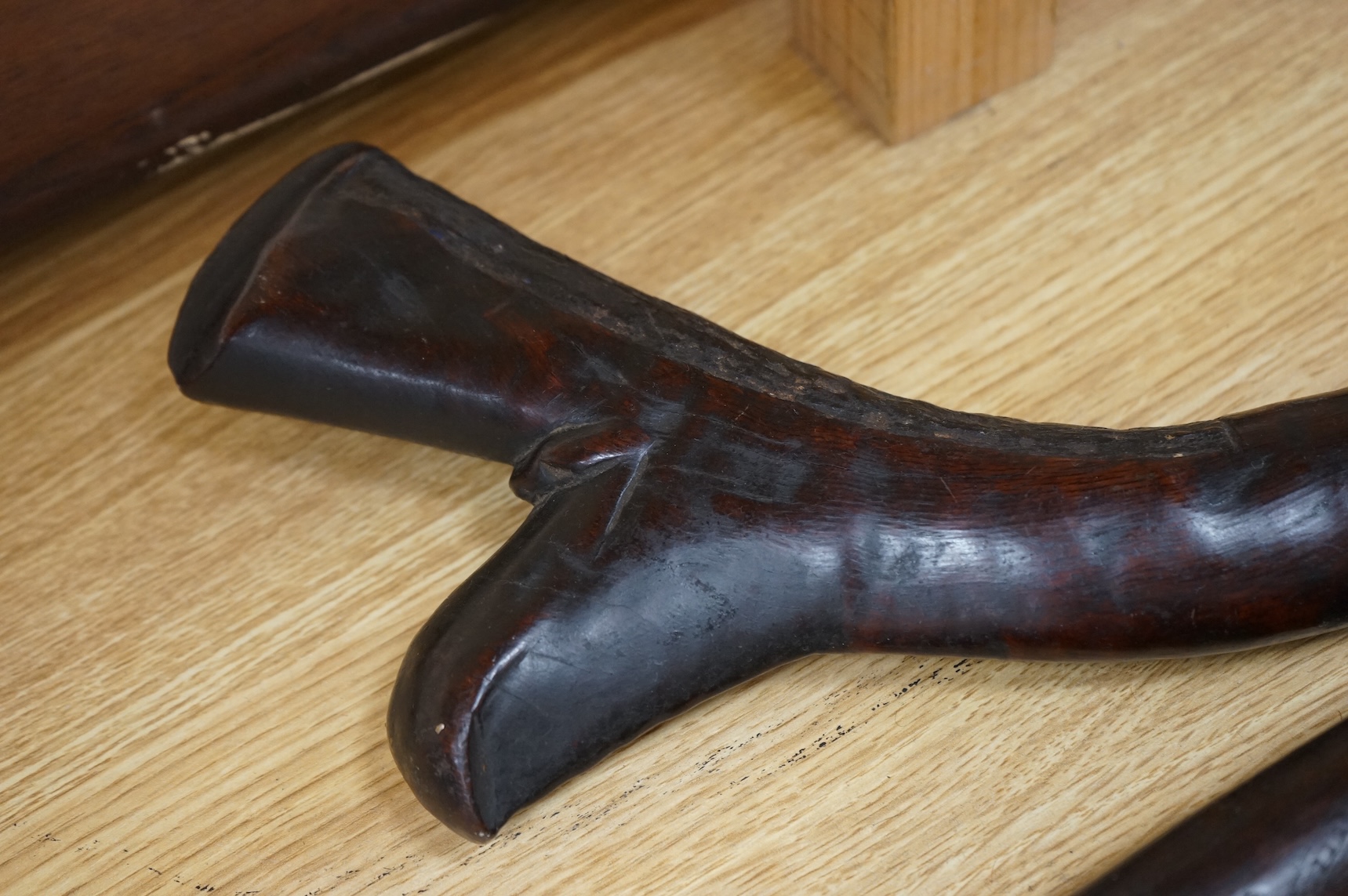A Fiji hardwood club, probably 19th century or earlier, of gunstock form, overall length 89cm, together with a pole club, probably from Samoa, and a wooden walking stick (3)